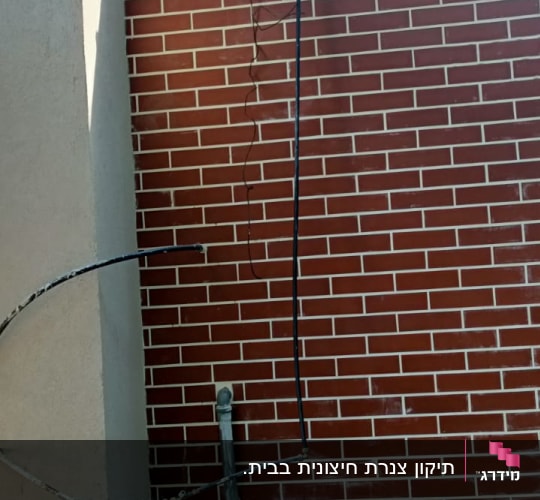 צינורות ומחברים ליד קיר לבנים אדום